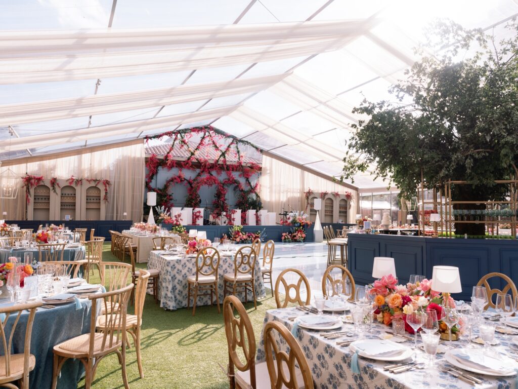 Tented wedding at Rosewood Mansion on Turtle Creek with colorful flowers, soft blue linens, and large trees