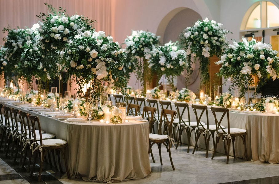 Wedding reception indoors in St Thomas at the Ritz Carlton, with long tables lined in large flower arrangements