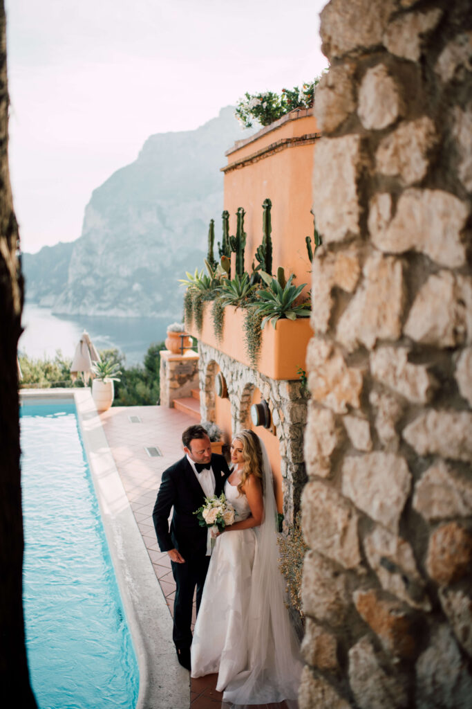 Wedding portrait at a venue in Capri, Italy, with the couple next to the pool and stone patio