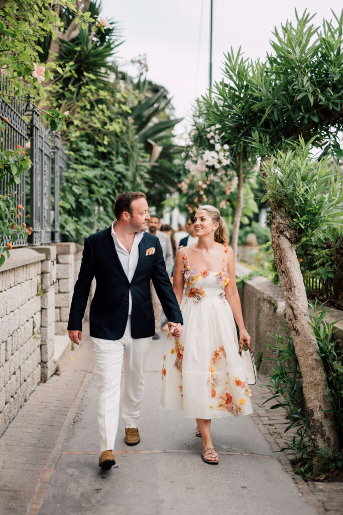 Bride and groom holding hands and walking to their rehearsal dinner in Capri, Italy