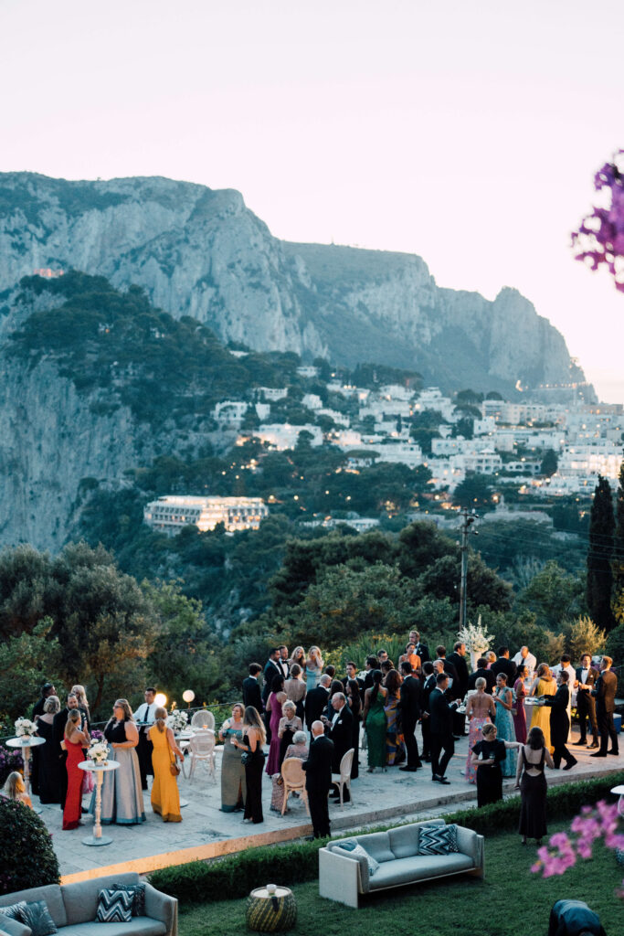 A view of the mountains in Capri, Italy with wedding guests mingling below