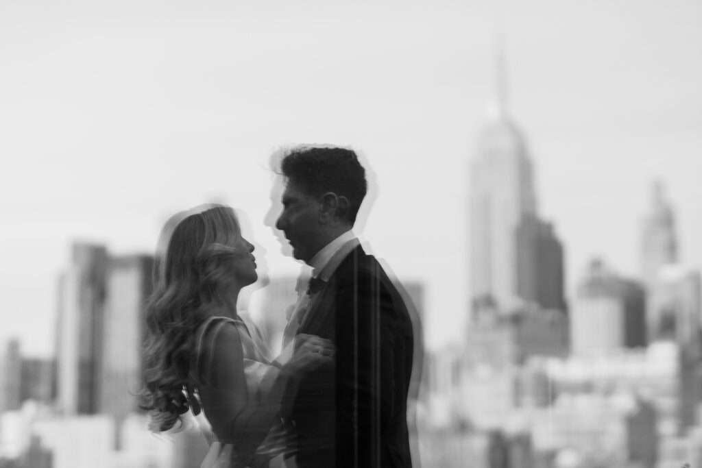 Black and white portrait of a couple, with the NYC skyline in the background