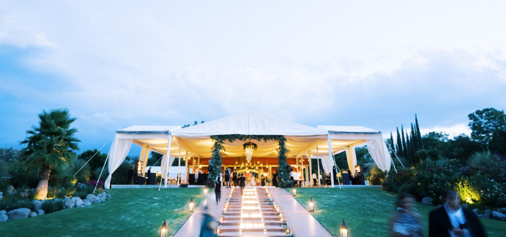 Landscape view of a tented wedding outdoors on the lawn of Rosewood in San Miguel de Allende